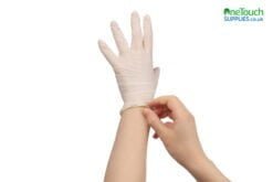 Woman puts on white rubber gloves.